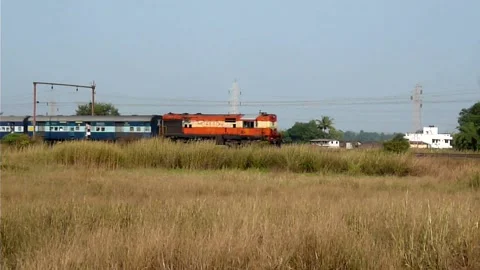 Long Indian Passenger express train crossing scenic Fields Shelu station India Video stock 140213523