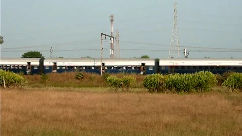 Long Indian Passenger express train crossing scenic Fields Shelu station India Stock Footage 140214512