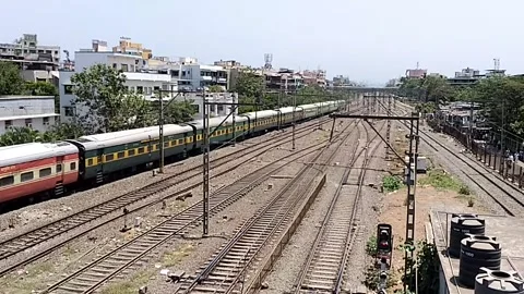 Long Indian Passenger express train in speed near Bhayander station Mumbai India Stock Footage 140893447