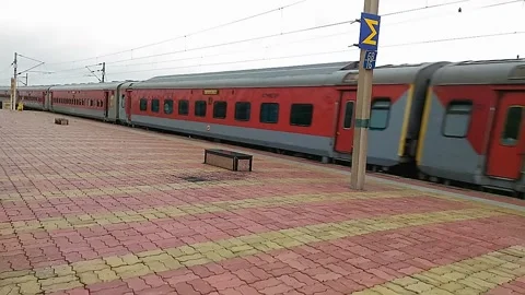 Long Indian Red Passenger express train crossing empty Vaitarna station India Stock Footage 140894666