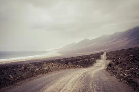 Long infinite off road path. wild beach and mountains destination. alternativ Foto stock