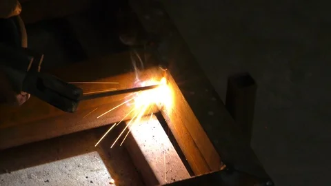 The long iron angles are being joined by welding using arc Stock Footage 112854231