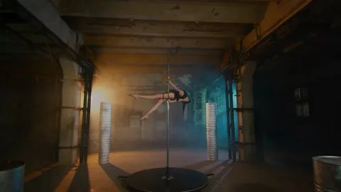 Long-legged sexy dancer climbs up the pylon and performs an acrobatic stunt. Stock Footage 134746699