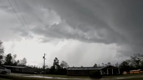 Long lightning strike behind homes in the country on a stormy cloudy day Stock Footage 176078432