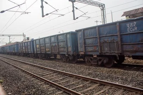 Long line of blue freight train wagons standing on railway tracks. Stock Photos