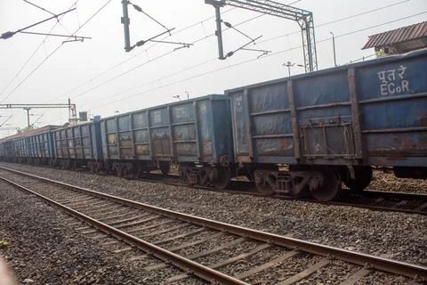 Long line of blue freight train wagons standing on railway tracks. Stock Photos