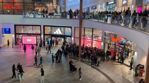 Long line of people in queue in front of a sports apparel store in a shopping Stock Footage 326571778