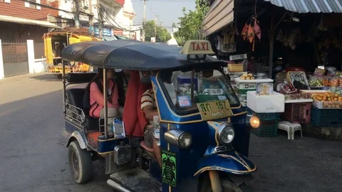 A long line of tuk tuks pull into a vegetable market carrying tourists. Stock Footage 72363951