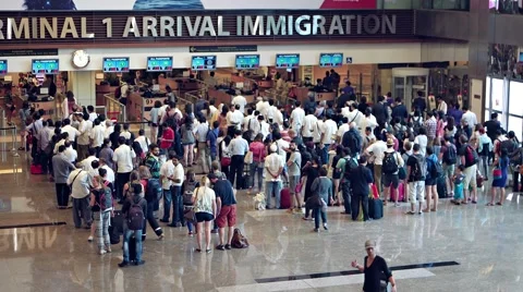 Long lines of travelers at the immigration counters in arrivals area Stock Footage