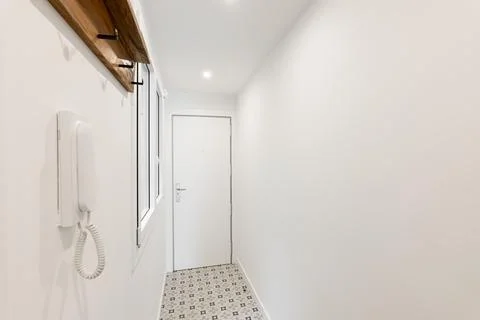 Long lobby with window and intercom on white wall at home 库存照片