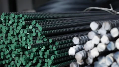 Long metallic bars rest in neat layers under a roof, set aside for bulk loading Stock Footage 314665014