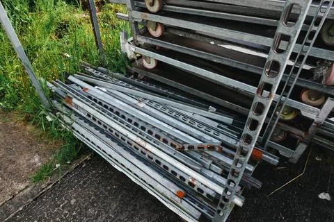 Long metallic objects are piled together, creating an industrial and rugged Stock Photos