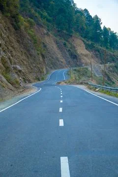 Long mountain empty curve road with greenery Stock Photos