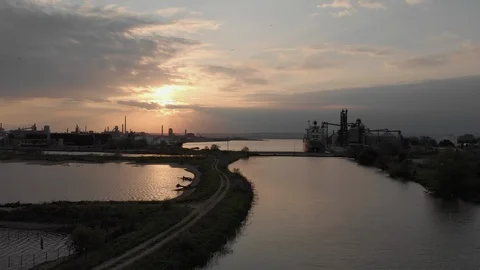 Long move over small inlet into hamilton harbour toward a large ship at sunset. Video stock 112633920