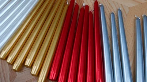 Long multicolor taper candles on light wooden surface, close-up  Vídeo Stock 89240620