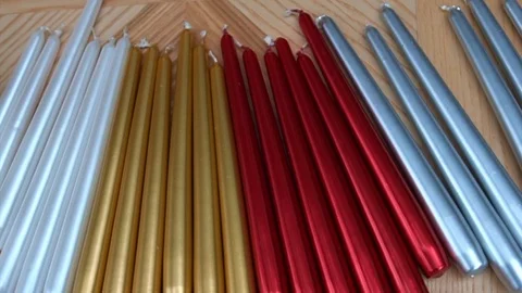 Long multicolor taper candles on light wooden surface, close-up  Video stock 89240621