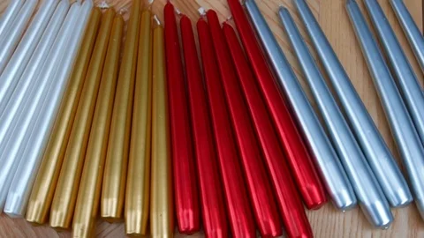 Long multicolor taper candles on light wooden surface, close-up  Video stock 89240642
