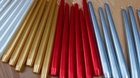 Long multicolor taper candles on light wooden surface, close-up  Video stock 89240662