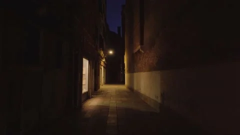 Long narrow dark empty street illuminated by window and lamp Stock Footage 162574763