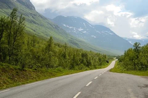 Long narrow mountain road going through the arctic summer mountain and valley Stock Photos