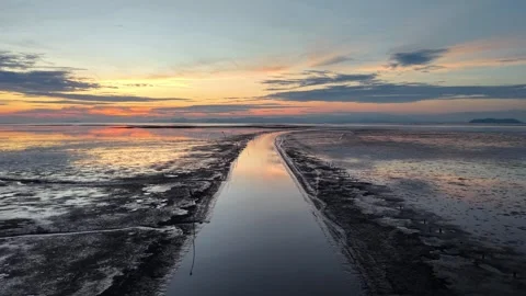 Long, narrow path runs through muddy coastal. Видео 329359403
