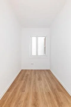 Long narrow rectangular room with white walls and wooden parquet, well lit by 库存照片