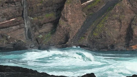 Long ocean waves rolling into volcanic coastline Stock Footage 334974769