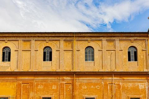 Long ochre facade with arched windows in the museum complex, Vatican Museum.. Stock Photos