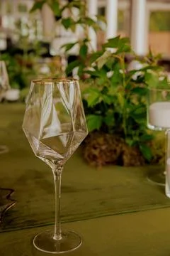 A long, ornate green table elegantly set with wine glass close up Stock Photos