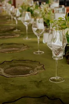 A long, ornate table elegantly set with plates and wine glasses Stock Photos