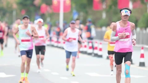 Long Pack of Marathon Runners Approaching on Race Course Stock Footage 348072032