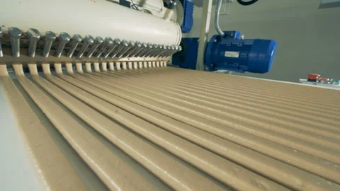 Long parallel lines of candy cream are flowing along the conveyor belt Stock Footage 86949710