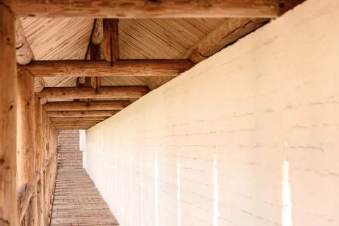 Long passage in the monastery on the background of the white-stone wall. Stock Photos