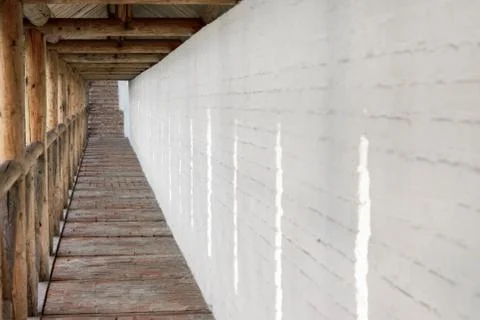 Long passage in the monastery on the background of the white-stone wall. Stock Photos