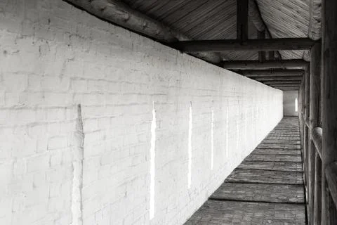 Long passage in the monastery on the background of the white-stone wall. Stock Photos