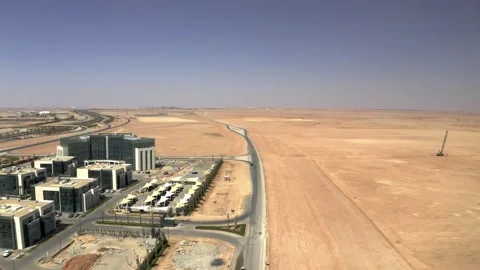 Long paved road between modern offices and desert construction 库存影片 346430476