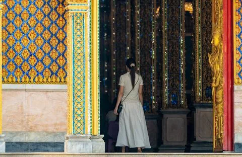 Long perspective corridor inside a Thai temple featuring golden frames, col.. 스톡 사진