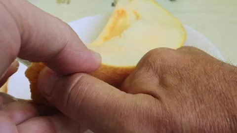 Long pieces are torn off with a knife from a juicy melon cut lengthwise. Me.. Stock Footage 287006691
