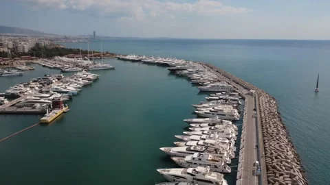 Long pier with luxury yachts aligned and sailboat in open sea Stock Footage 338108533