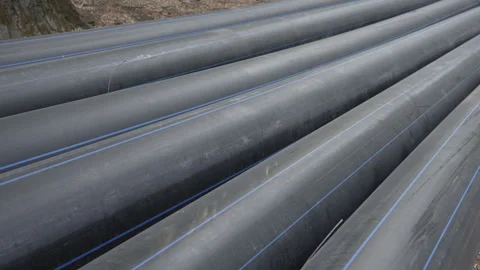 Long plastic black pipes of large diameter lie on the street. Stock Footage 287686299