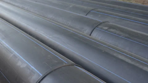 Long plastic welded black pipes of large diameter lie on the street. Close-up Stock Footage 287416770