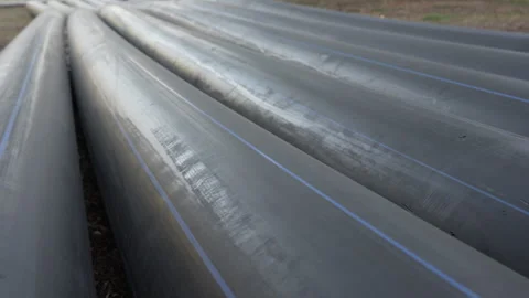 Long plastic welded black pipes of large diameter lie on the street. Close-up Stock Footage 289140282