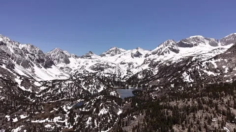Long Pullback From Snowy Sierra Wall Over Blue Lake and Evergreen Basin Vídeos de archivo 336222863