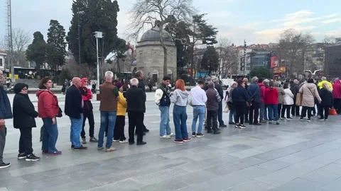 Long queue at city street. Many people stand in line. Men group wait outdoor. Stock Footage 307423259