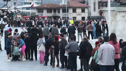 Long queue at city street. Many people stand in line. Men group wait outdoor. Stock Footage 307423422