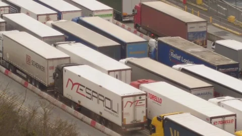 Long queue of commercial semi trucks stuck in a traffic jam at a cargo terminal Stockbeeldmateriaal 346505539