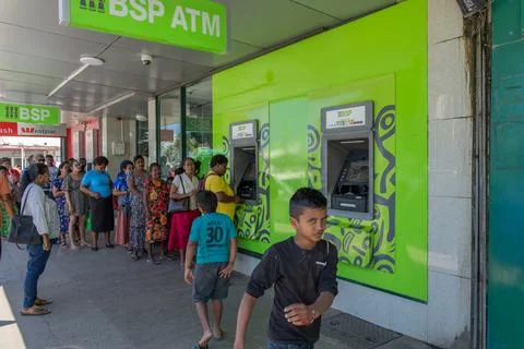 Long queue or line of people in street queuing outside ATM to get cash out. Stock Photos