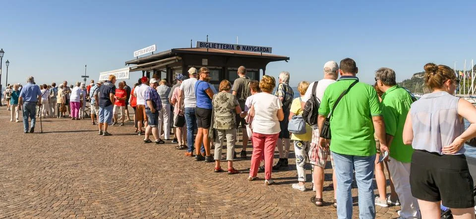 Long queue of people queuing to buy tickets for a ferry in Lake Garda Stock Photos