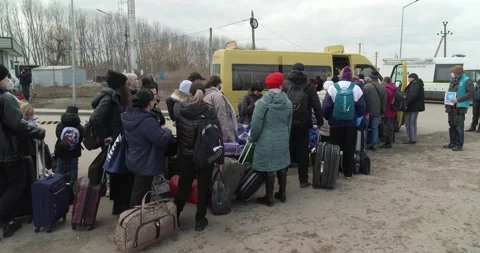Long queue of refugees with bags and suitcases to get into golden-colored van 4K Stock Footage 196800955