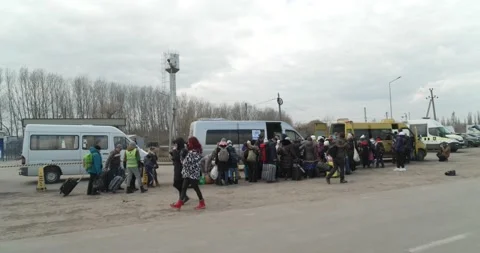 Long queue of refugees waiting to get seated in vans 4K Stock Footage 196801014